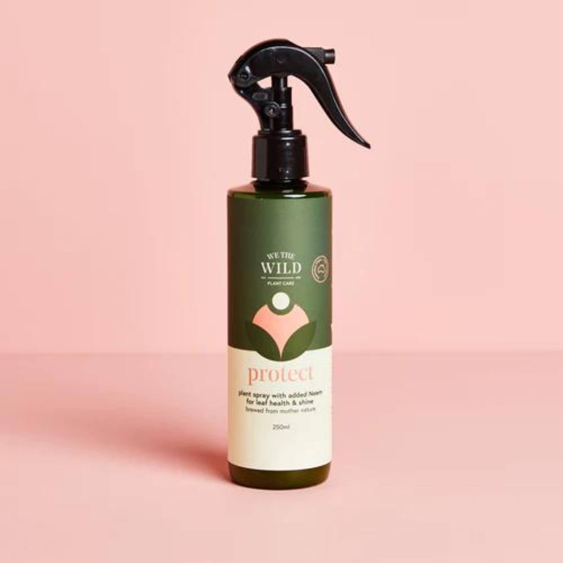 We the Wild Protect Plant Spray Bottle on pink background.